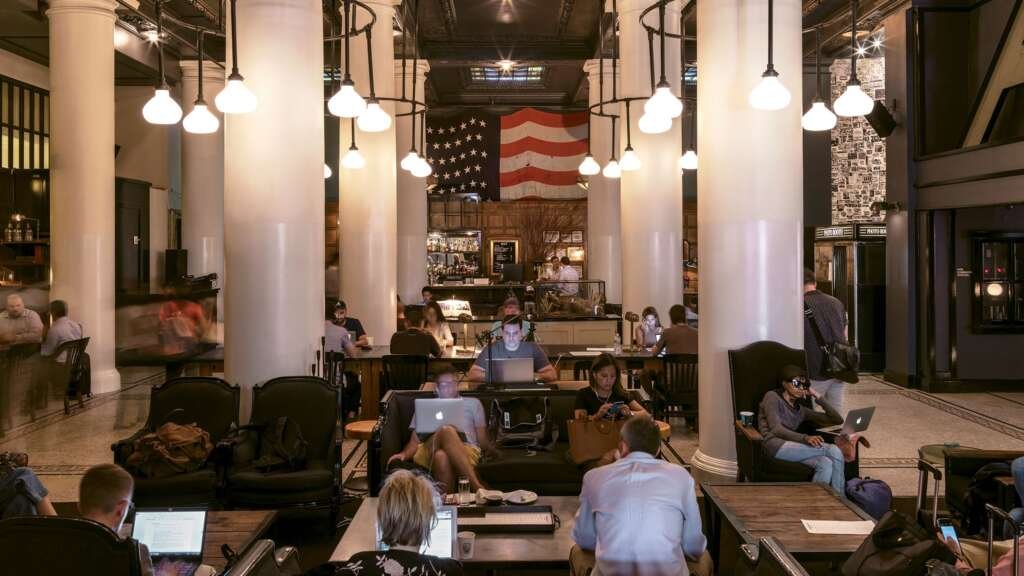 hybrid hospitality space where a hotel lobby functions as both a co-working area.