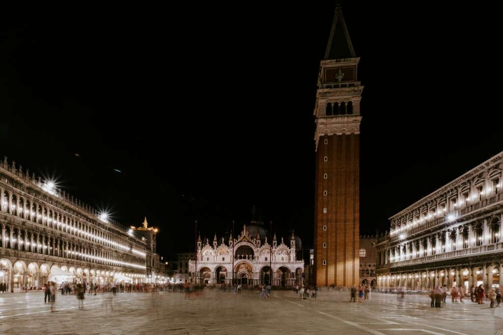 night view of st. mark’s square in venice with st. mark’s basilica and the campanile illuminated.